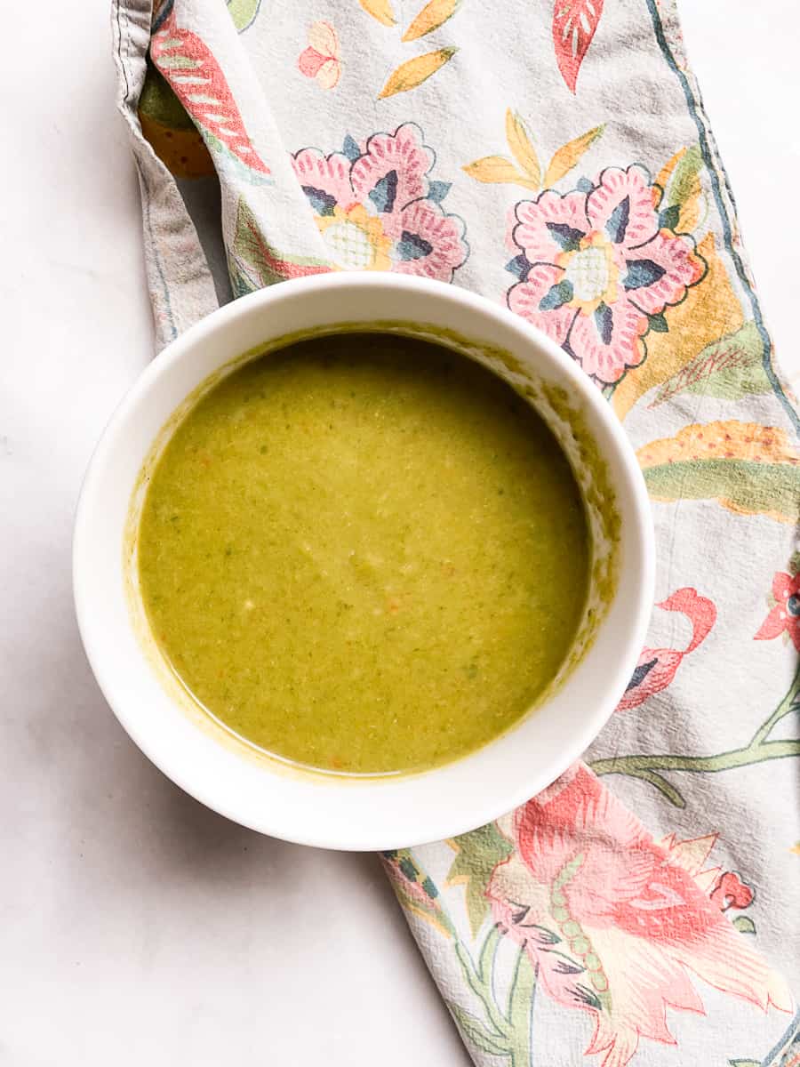 A bowl of vegan asparagus soup on a blue napkin.