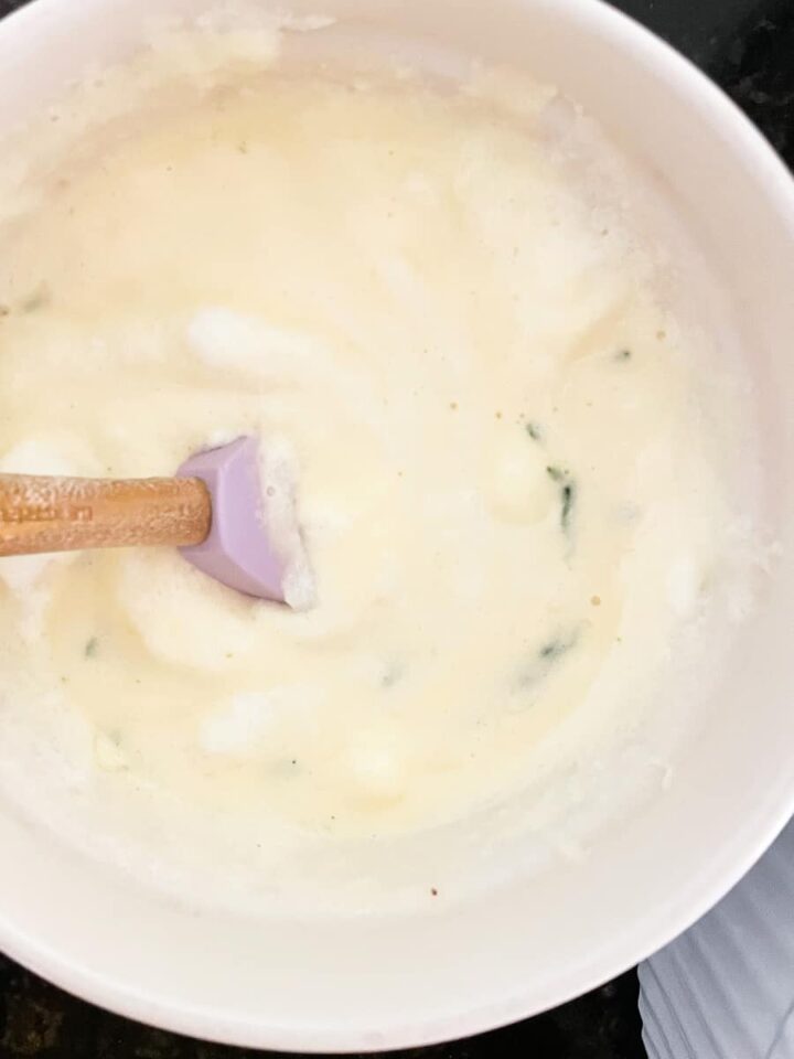 The fluffiest gluten free souffle with spinach and parmesan cheese is easily made gluten-free by using sweet white rice flour. The base and egg whites are combined with a rubber spatula.