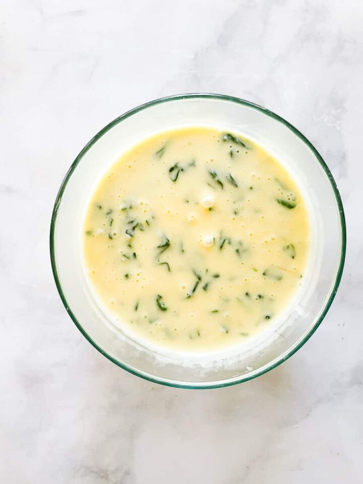 The fluffiest gluten free souffle with spinach and parmesan cheese is easily made gluten-free by using sweet white rice flour. The souffle base with spinach in a glass bowl.