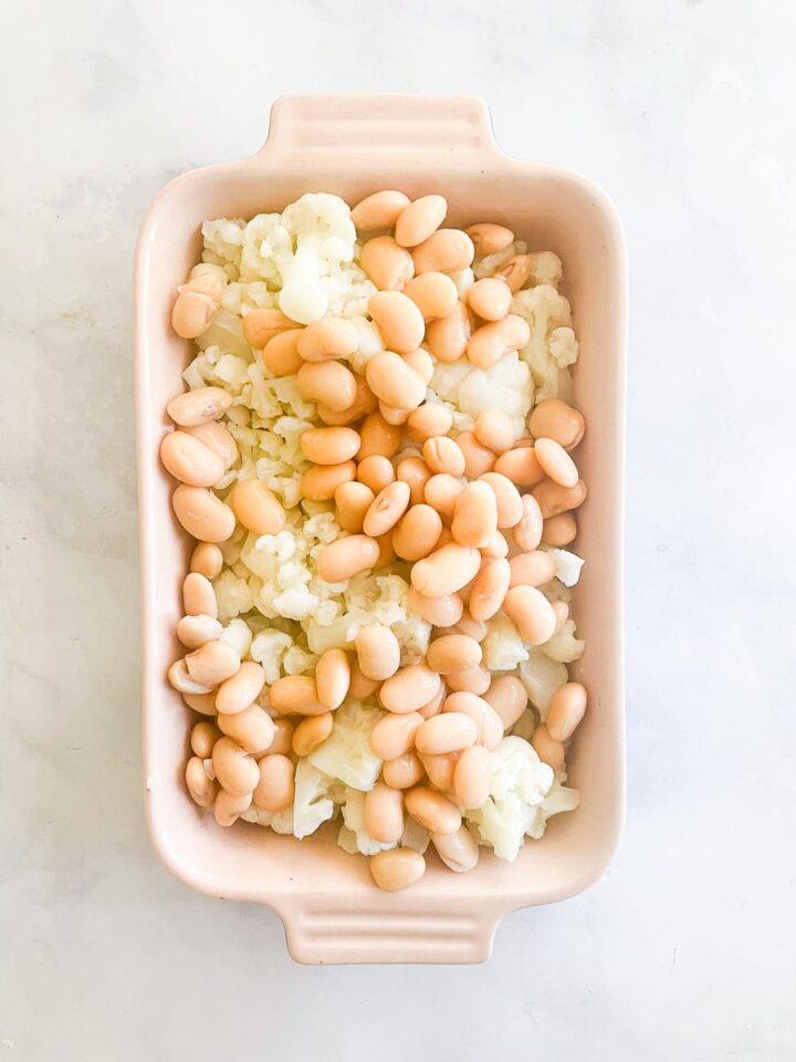 Butter beans are added to the top of the cauliflower.