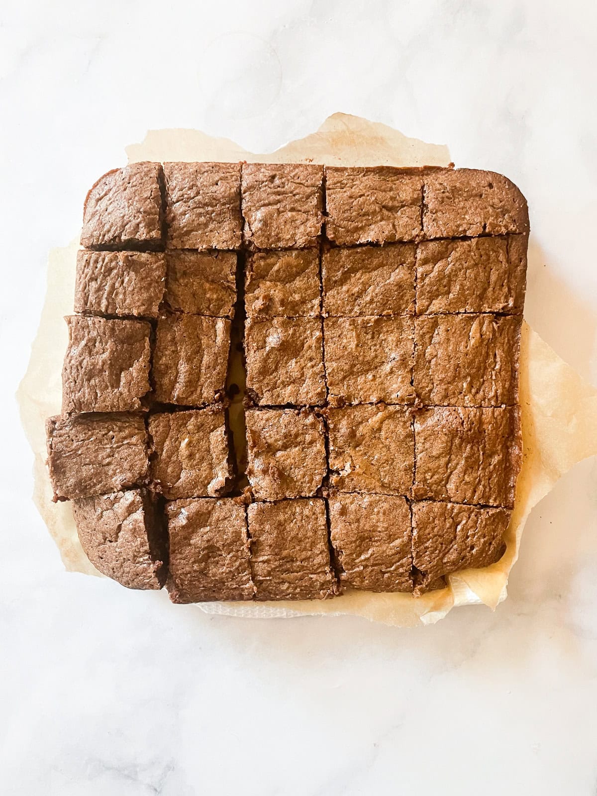 Rich whole wheat brownies are just like your favorite brownie recipe but made with whole wheat flour and melted chocolate. Whole wheat brownies cut into squares.