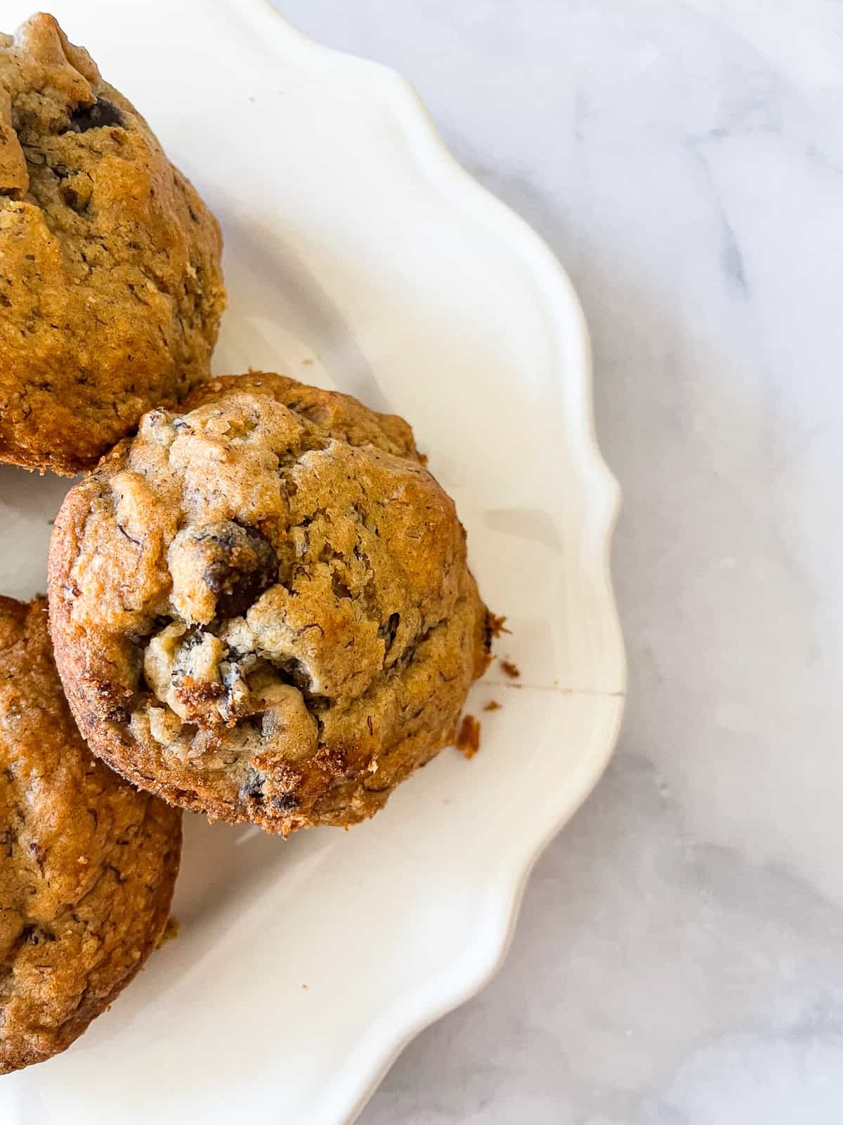 Chocolate chips peek out of a vegan banana muffin.