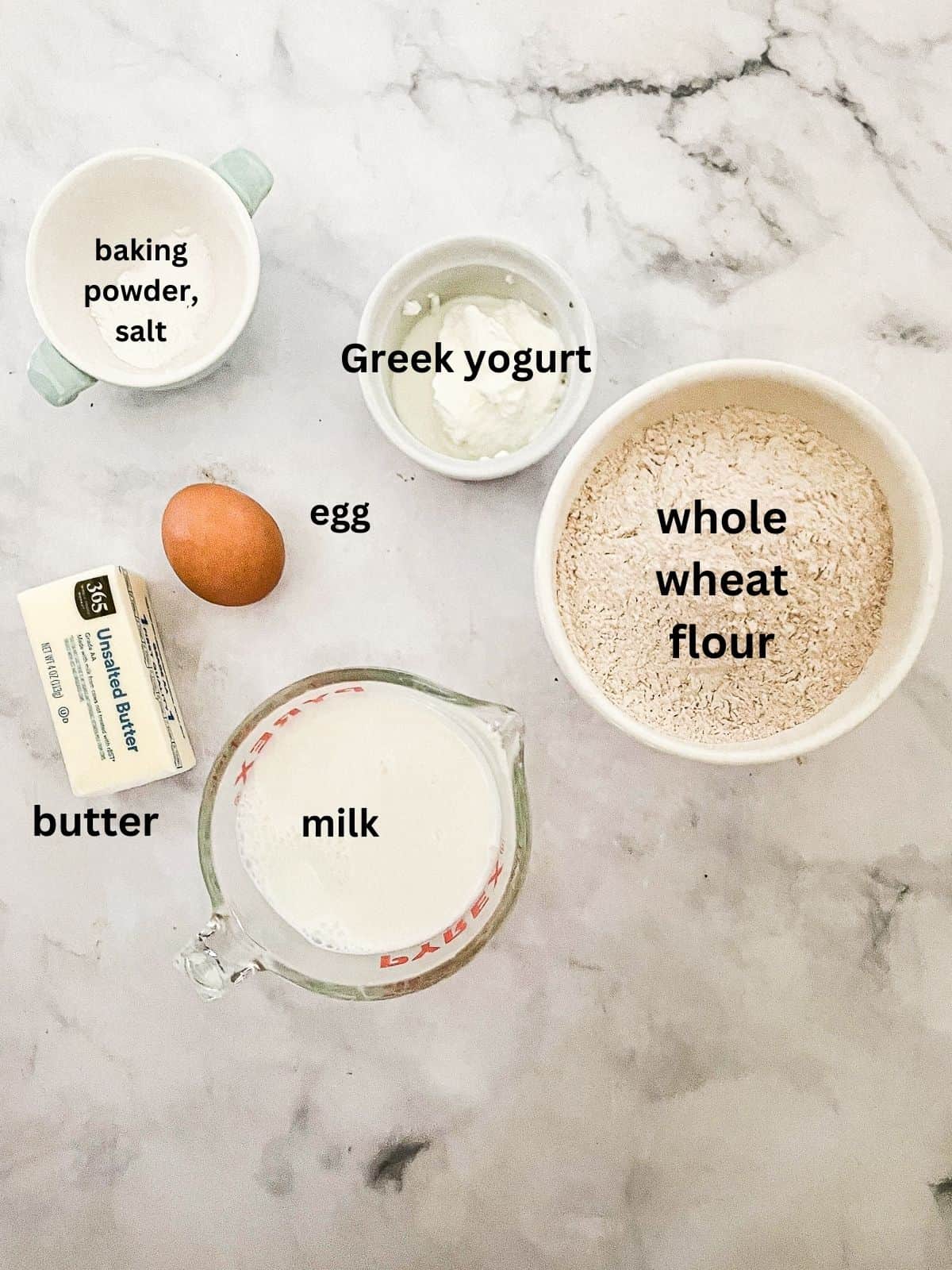 Fluffy whole wheat waffles made with whole grain flour, Greek yogurt, and melted butter! Perfect for a lazy weekend morning. Ingredients for whole wheat waffles are text-labeled.