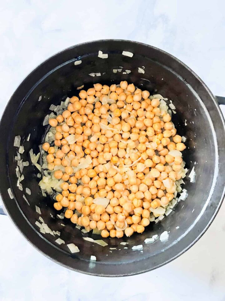 Easy curried chickpeas with coconut and spinach are spiked with fresh lemon juice. Serve over brown rice or quinoa for a gluten-free dinner. Chickpeas cook in onion and garlic and ginger.
