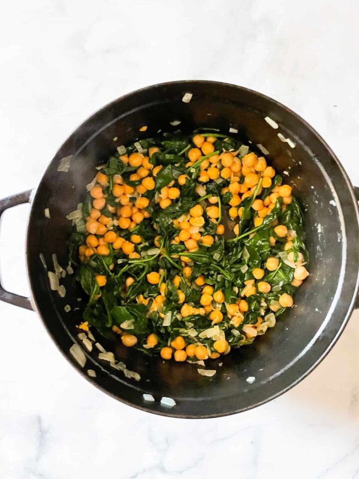 Easy curried chickpeas with coconut and spinach are spiked with fresh lemon juice. Serve over brown rice or quinoa for a gluten-free dinner. Spinach cooks with chickpeas in a pot.