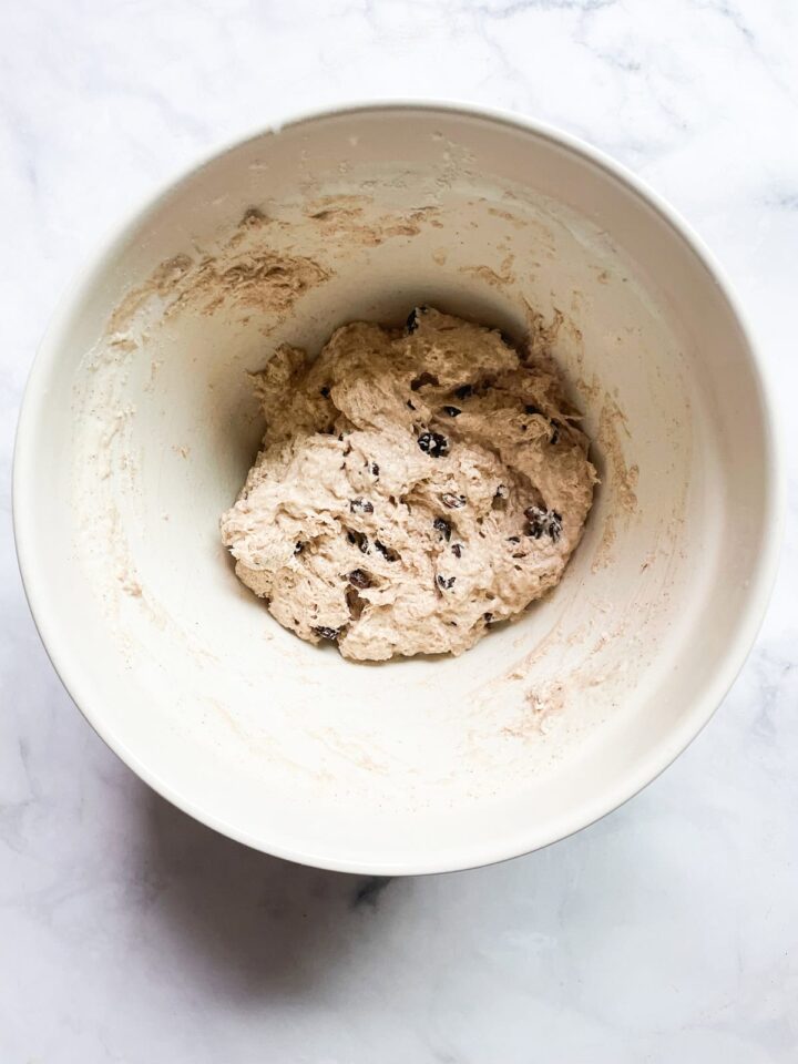 Easy no knead cinnamon raisin bread benefits from a long overnight rise and a bake in a hot Dutch oven! A fantastic recipe for beginners. Cinnamon raisin bread dough after being mixed in a bowl.