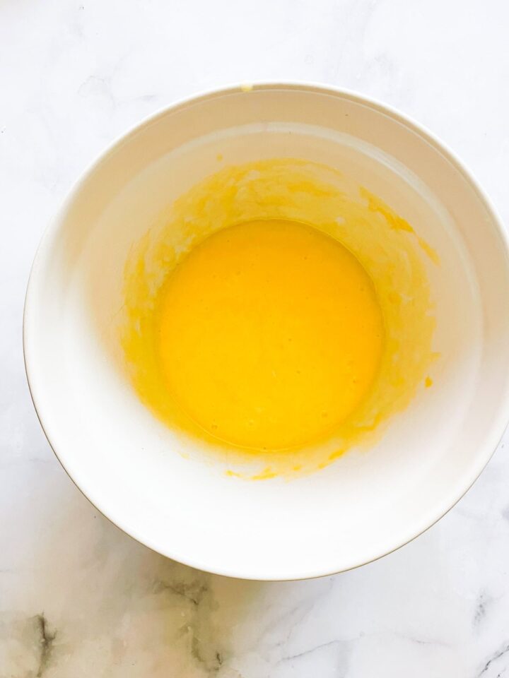 This classic French-inspired lemon yogurt cake is a reliable one-bowl recipe that always turns out perfectly. Eggs, yogurt, and sugar mixed in a bowl.