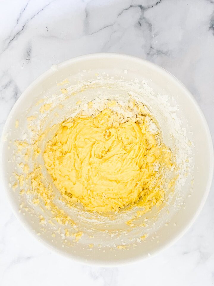 These adorable unicorn bars are perfect for a kid's birthday party! A buttermilk funfetti sheet cake is topped with blue icing and plenty of sprinkles. Flour is added to butter, sugar, and eggs.