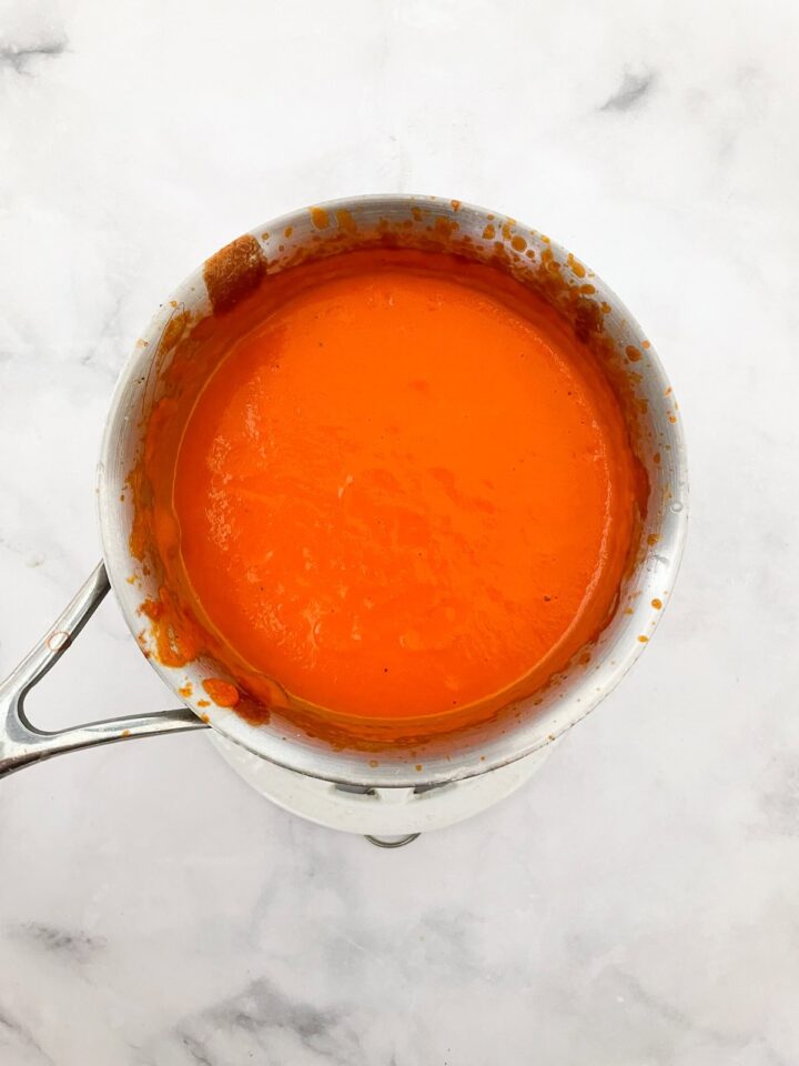 Rich and velvety smooth vegetarian cream of tomato soup is the definition of comfort food-perfect on its own or paired with grilled cheese. Vegetarian cream of tomato soup in a pot.