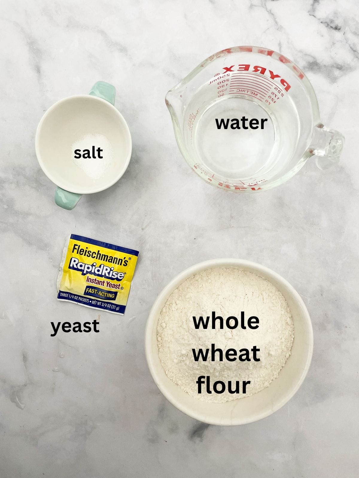 This easy no knead whole wheat bread is my version of the beloved no-knead bread recipe made with whole grain flour. Ingredients for no knead whole wheat bread are text-labeled.