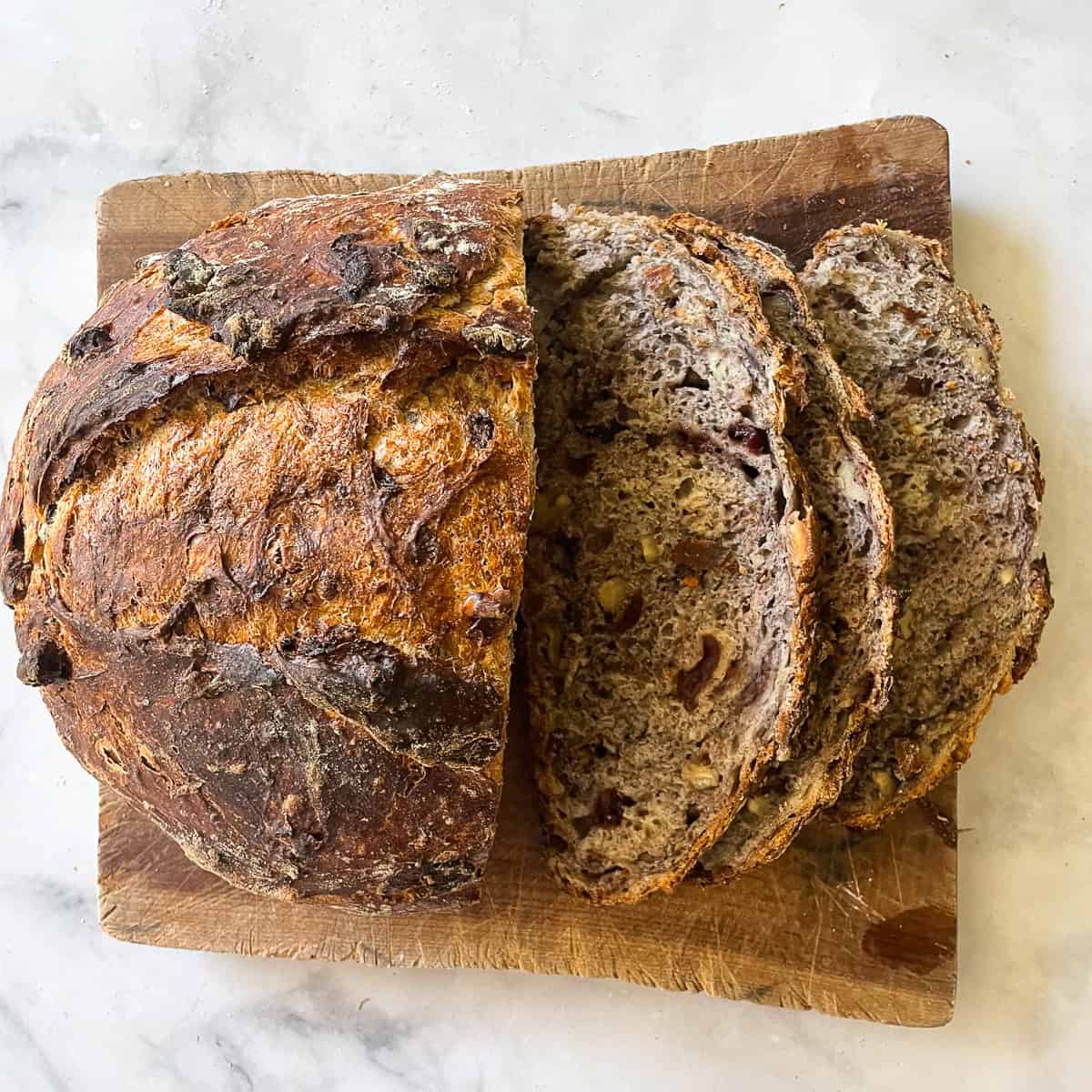 Slices of cranberry walnut bread cut from a loaf.
