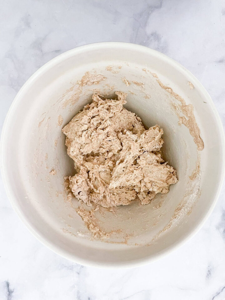 This porridge bread recipe turns leftover oatmeal into a beautifully soft and wholesome loaf! A great way to make sure nothing goes to waste. Mixed dough in a bowl.