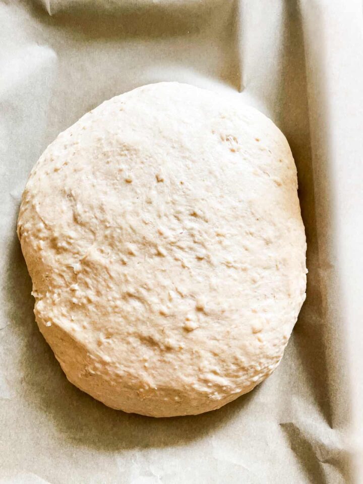 This porridge bread recipe turns leftover oatmeal into a beautifully soft and wholesome loaf! A great way to make sure nothing goes to waste. Bread dough on a lined baking sheet.