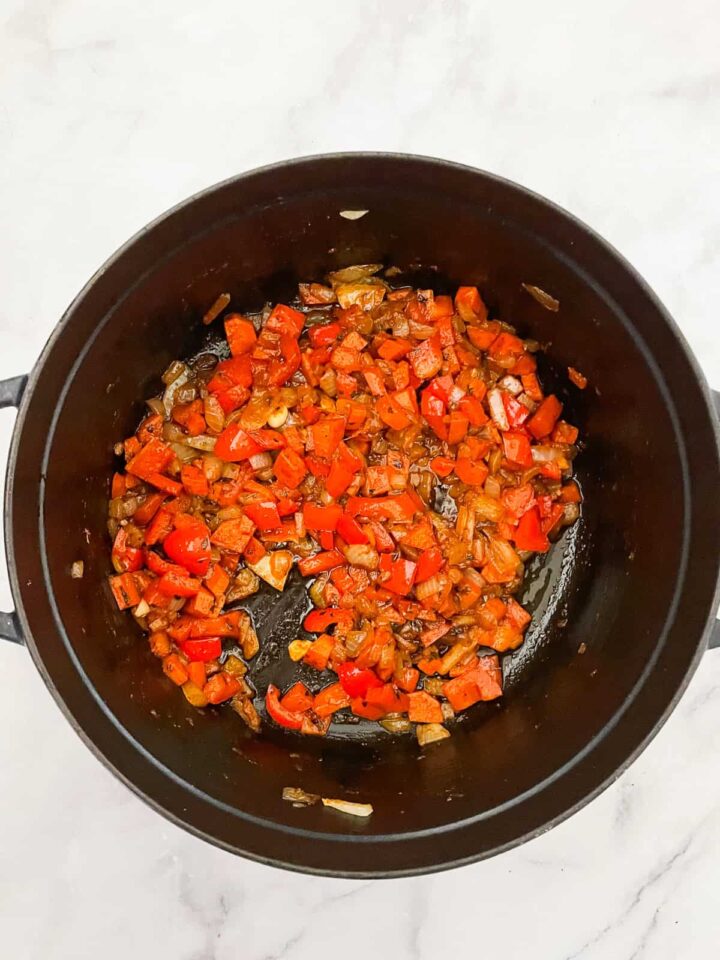 Dig into a hearty bowl of vegetarian white chili that features tender white beans swirled in a rich tomatoey base. The veggie base for chili cooks in a pot.