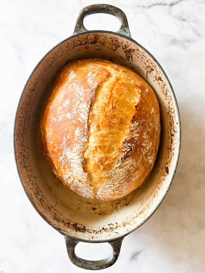 This easy no knead whole wheat bread is my version of the beloved no-knead bread recipe made with whole grain flour. A loaf of whole wheat bread after baking 20 minutes uncovered.