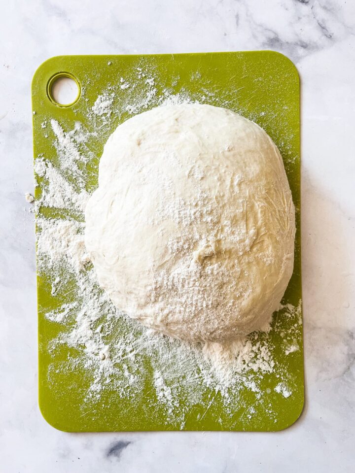 This easy no knead whole wheat bread is my version of the beloved no-knead bread recipe made with whole grain flour. Dough for whole wheat bread on a board.