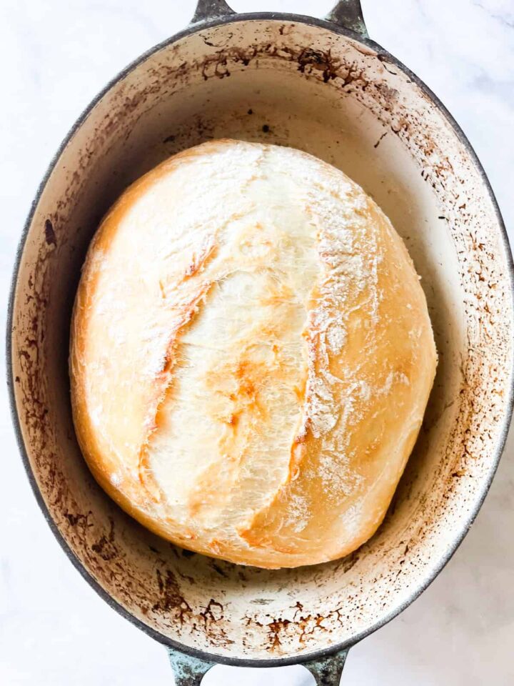 This easy no knead whole wheat bread is my version of the beloved no-knead bread recipe made with whole grain flour. A loaf of no knead whole wheat bread after baking 30 minutes covered.