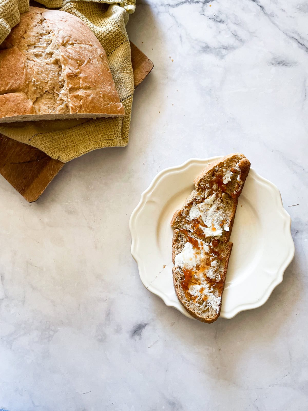 A loaf of leftover porridge bread and a slice of bread on a plate.