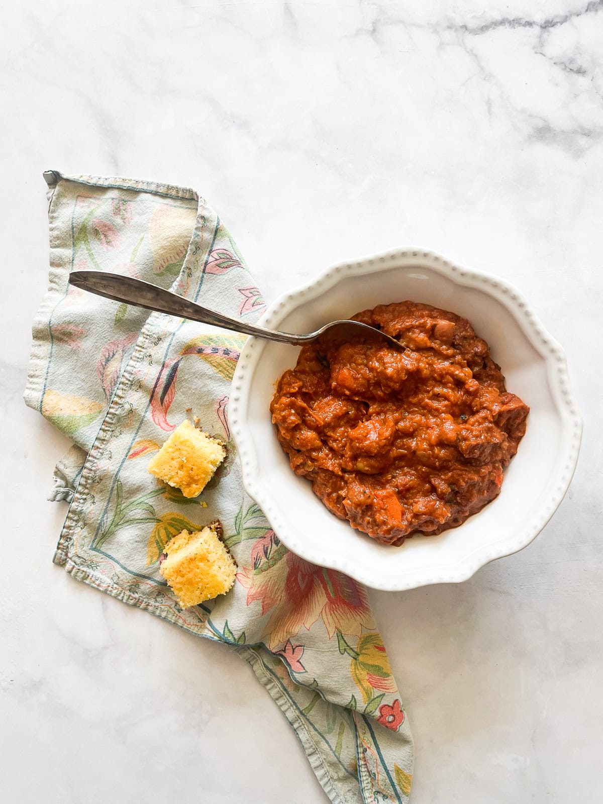 A bowl of vegetarian white chili served with cornbread.