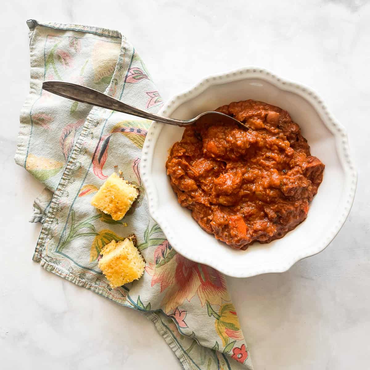 A bowl of vegetarian white chili served with cornbread.