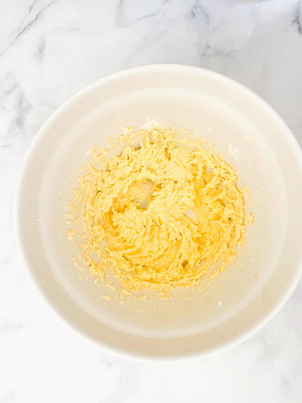 This gorgeous upside-down rhubarb cake drapes buttery rhubarb over a vanilla-scented cake for a beautiful, summery treat. Butter, sugar, and egg mixed in a bowl.