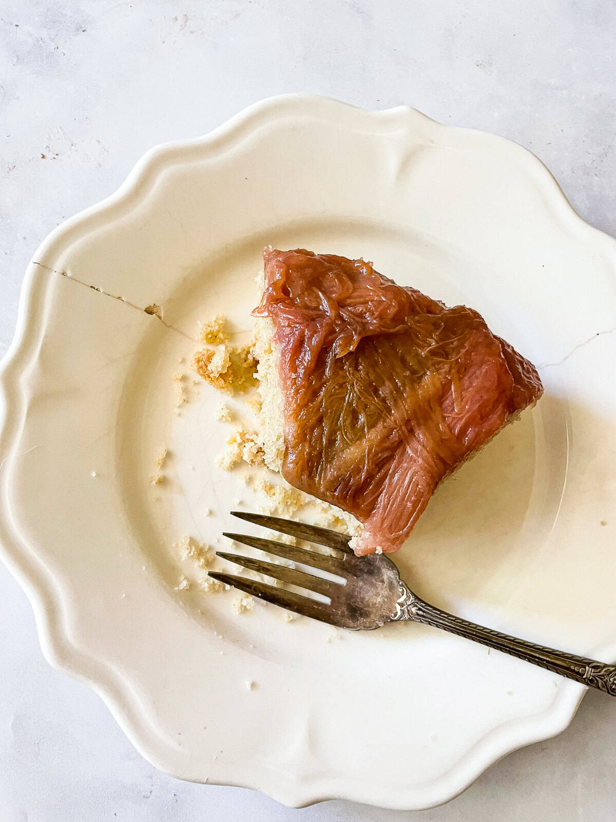 This gorgeous upside-down rhubarb cake drapes buttery rhubarb over a vanilla-scented cake for a beautiful, summery treat. A slice of upside-down rhubarb cake with a fork.