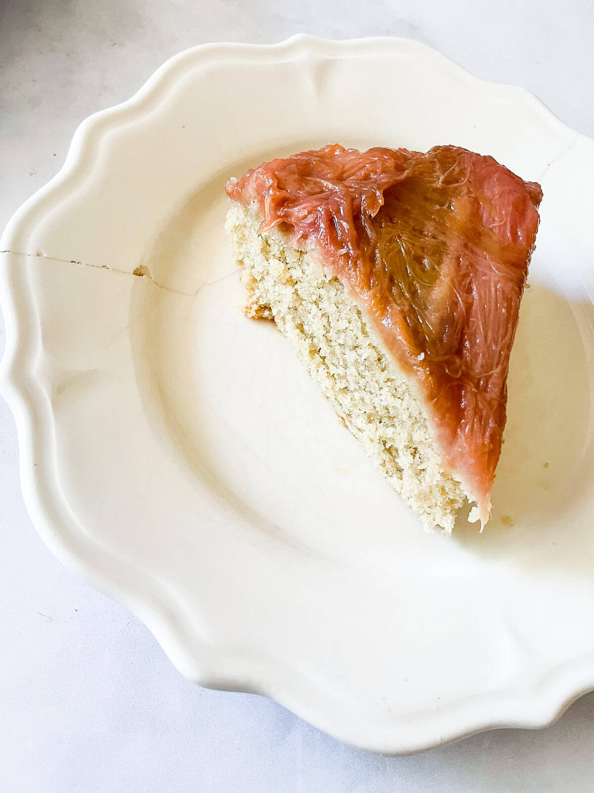 This gorgeous upside-down rhubarb cake drapes buttery rhubarb over a vanilla-scented cake for a beautiful, summery treat. A slice of upside-down rhubarb cake on a plate.