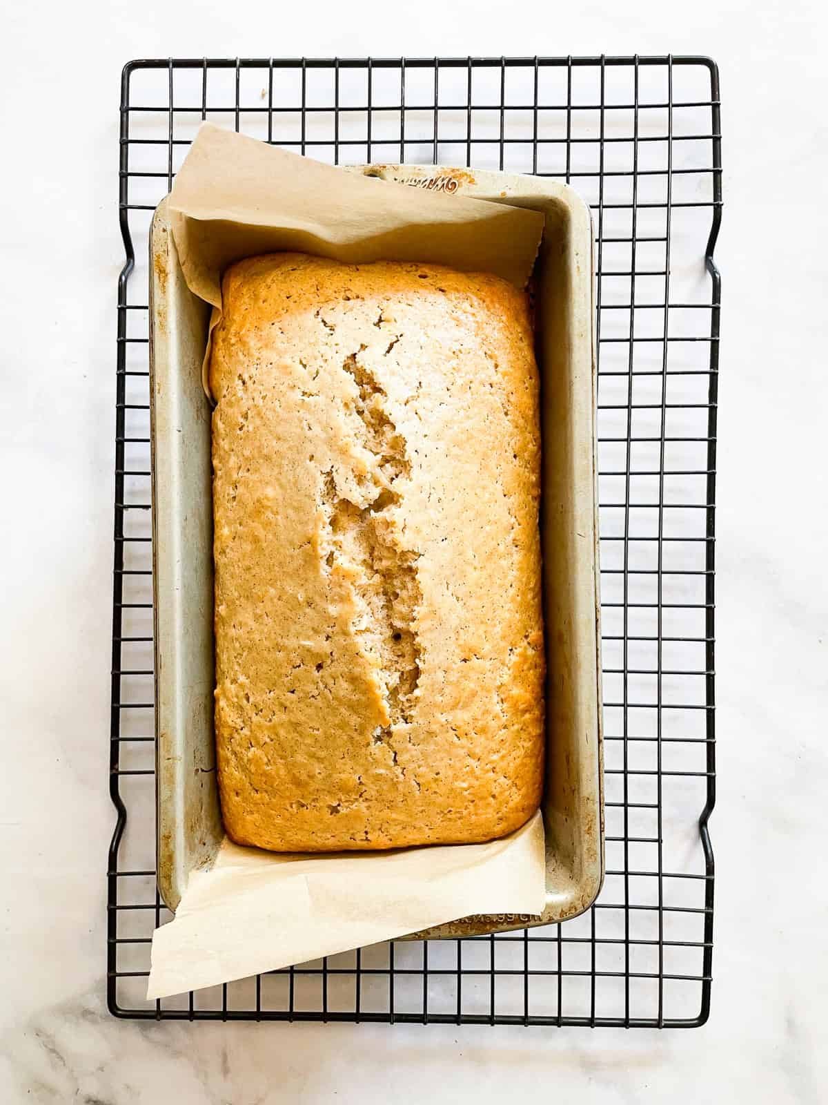 A cinnamon-kissed coconut loaf cake packed with bits of flaked coconut. Inspired by the classic Bill Granger recipe from "Australian Food." A loaf of coconut cake cools in the tin.