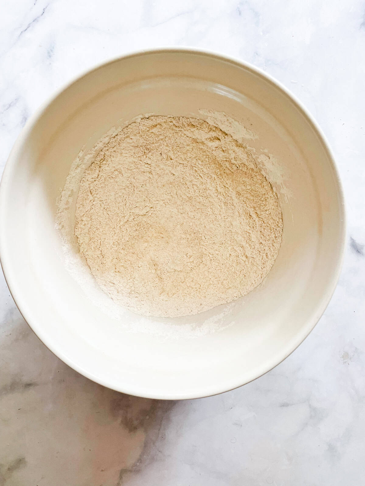 A cinnamon-kissed coconut loaf cake packed with bits of flaked coconut. Inspired by the classic Bill Granger recipe from "Australian Food." Dry mix for coconut loaf cake in a bowl.