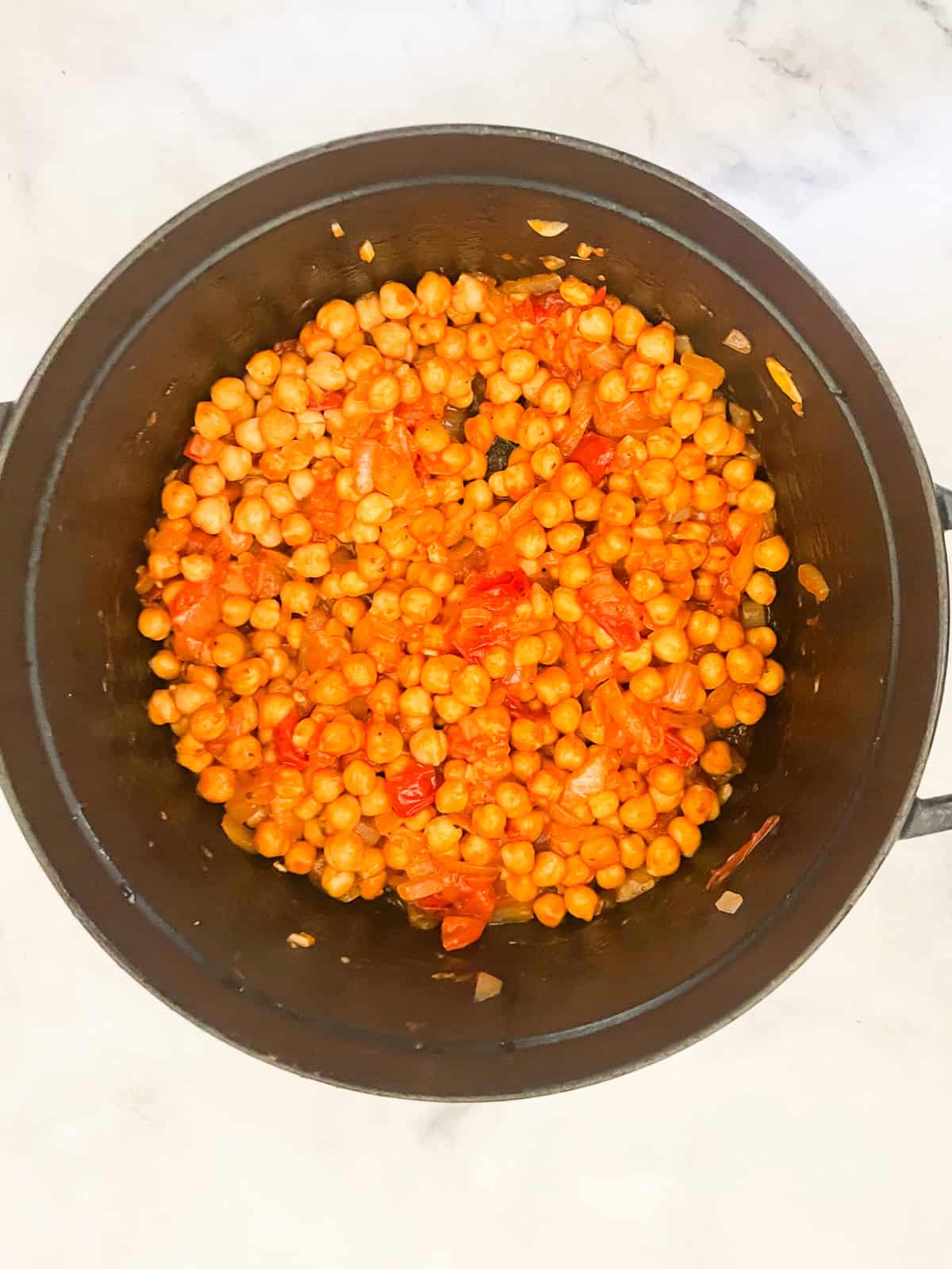 Marry me chickpeas is a vegetarian twist on a popular dish, featuring tender chickpeas and spinach in a tomato broth plus a splash of cream. Chickpeas and tomato paste are added to the pot.