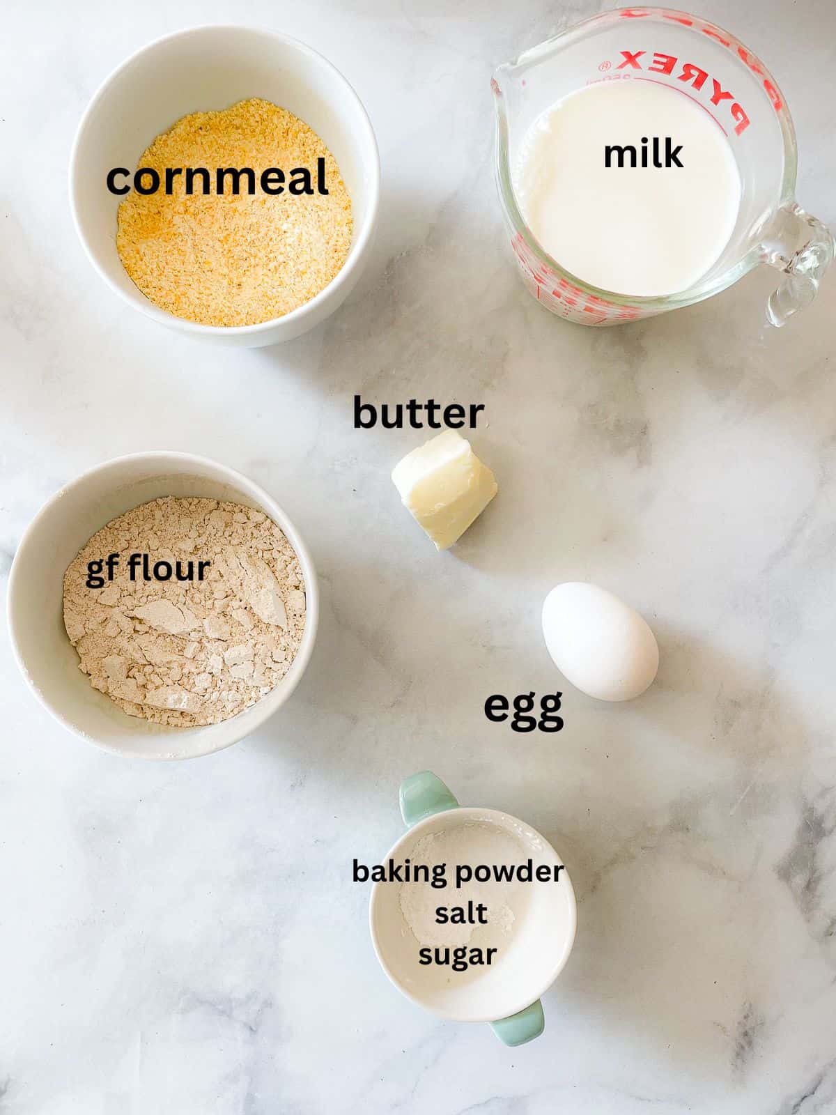 A simple recipe for gluten free cornbread muffins that are as welcome on the Thanksgiving table as they are with a bowl of soup. Ingredients for gluten free cornbread muffins are text labeled.