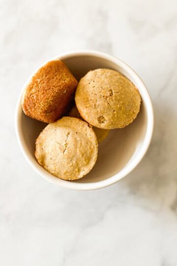 A white bowl of gluten free cornbread muffins.