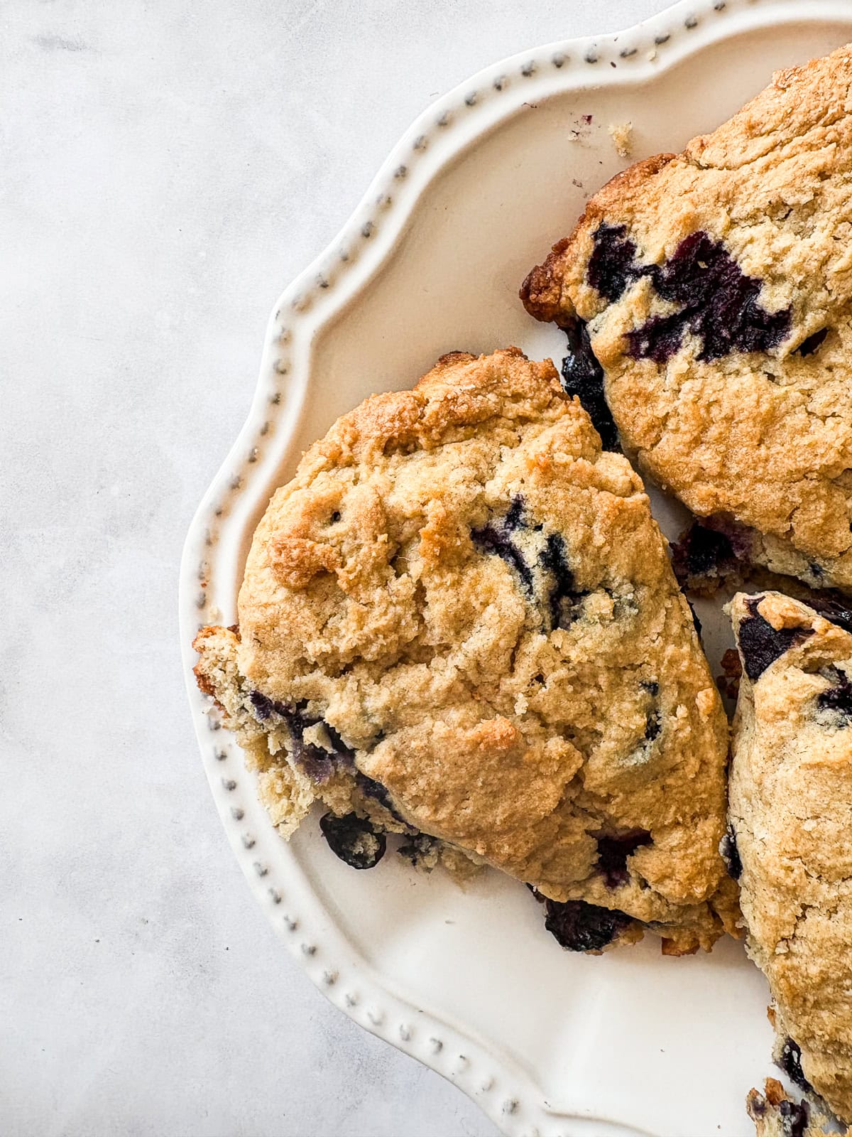 Blueberries peek out of a batch of blueberry lemon scones.