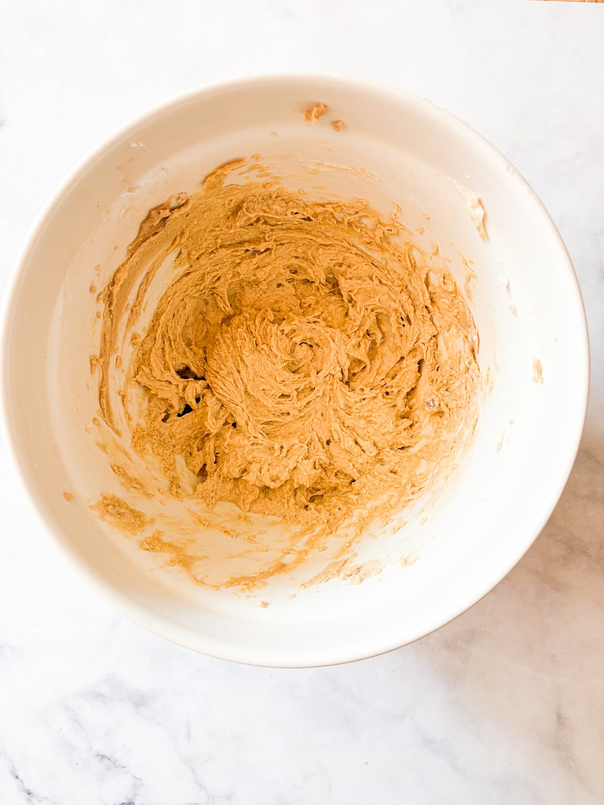This buttery chocolate chip cookie cake is made with whole wheat flour and brown sugar for a touch of caramel sweetness. Butter and sugar creamed in a bowl.