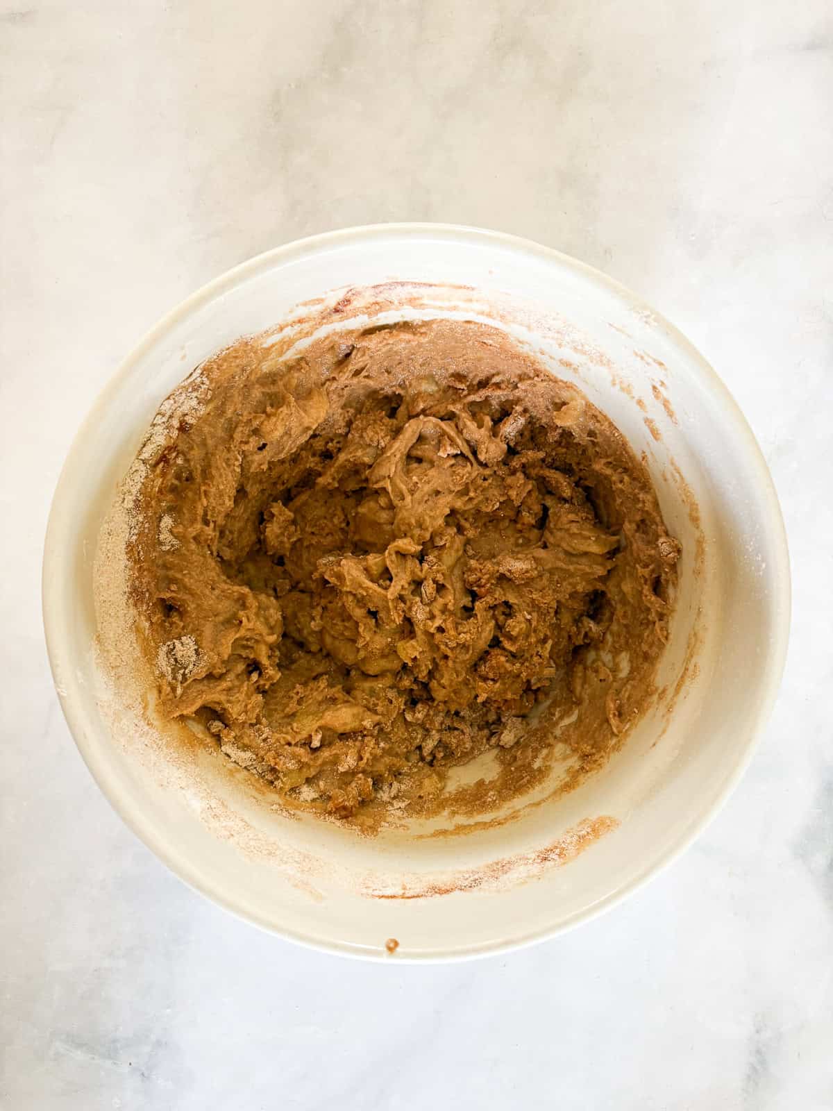 These perfect bite-sized mini banana muffins are made with whole-grain flour, maple syrup, and heart-healthy olive oil. The full batter for mini banana muffins.