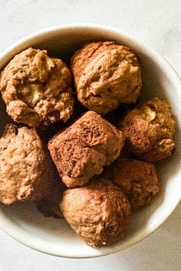 A bunch of mini banana muffins in a white bowl.