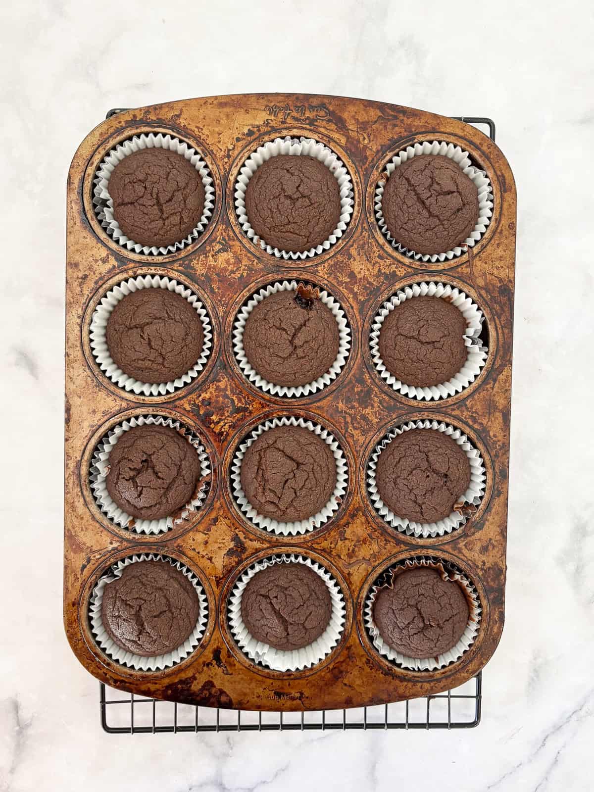 Tender, chocolatey vegan chocolate cupcakes frosted with a sumptuous vegan chocolate buttercream are out-of-this-world good! A batch of vegan chocolate cupcakes cools in the pan.